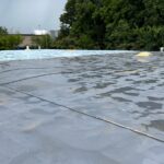 flat commercial roof undergoing a coating process
