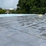 flat commercial roof undergoing a coating process