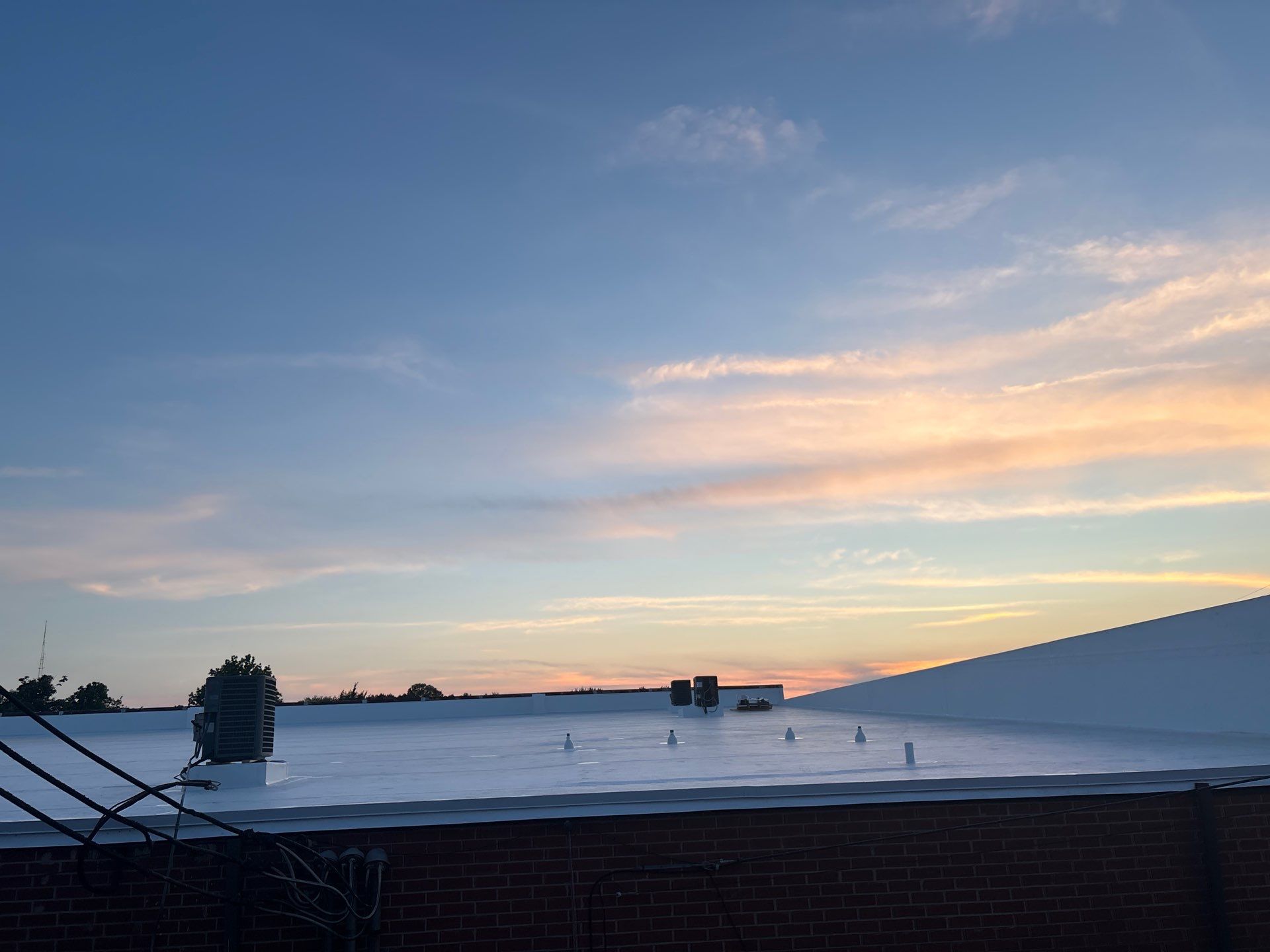 Sunset view of completed commercial roof project