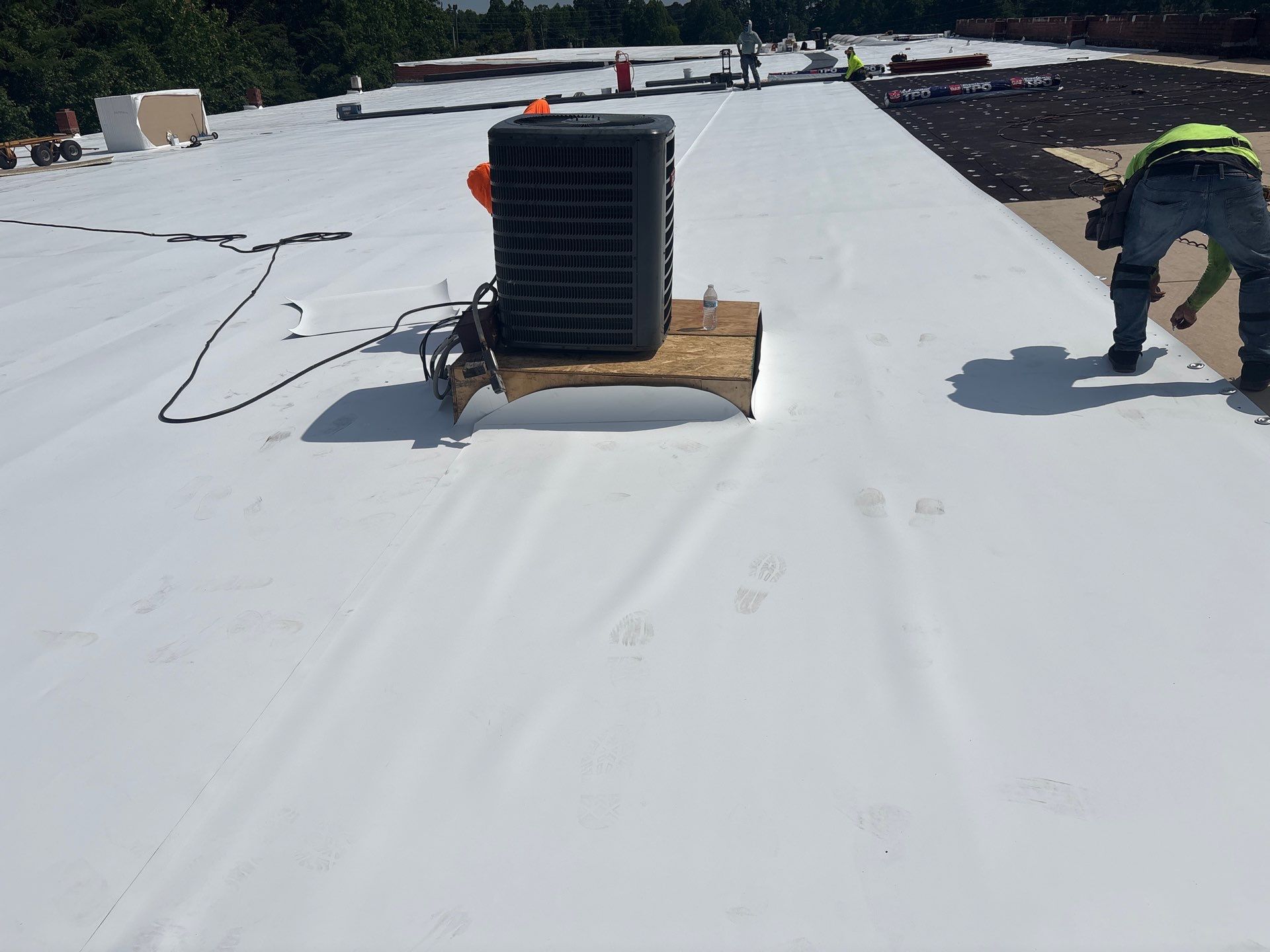 Technician performing commercial roofing on a commercial roof in High Point, NC