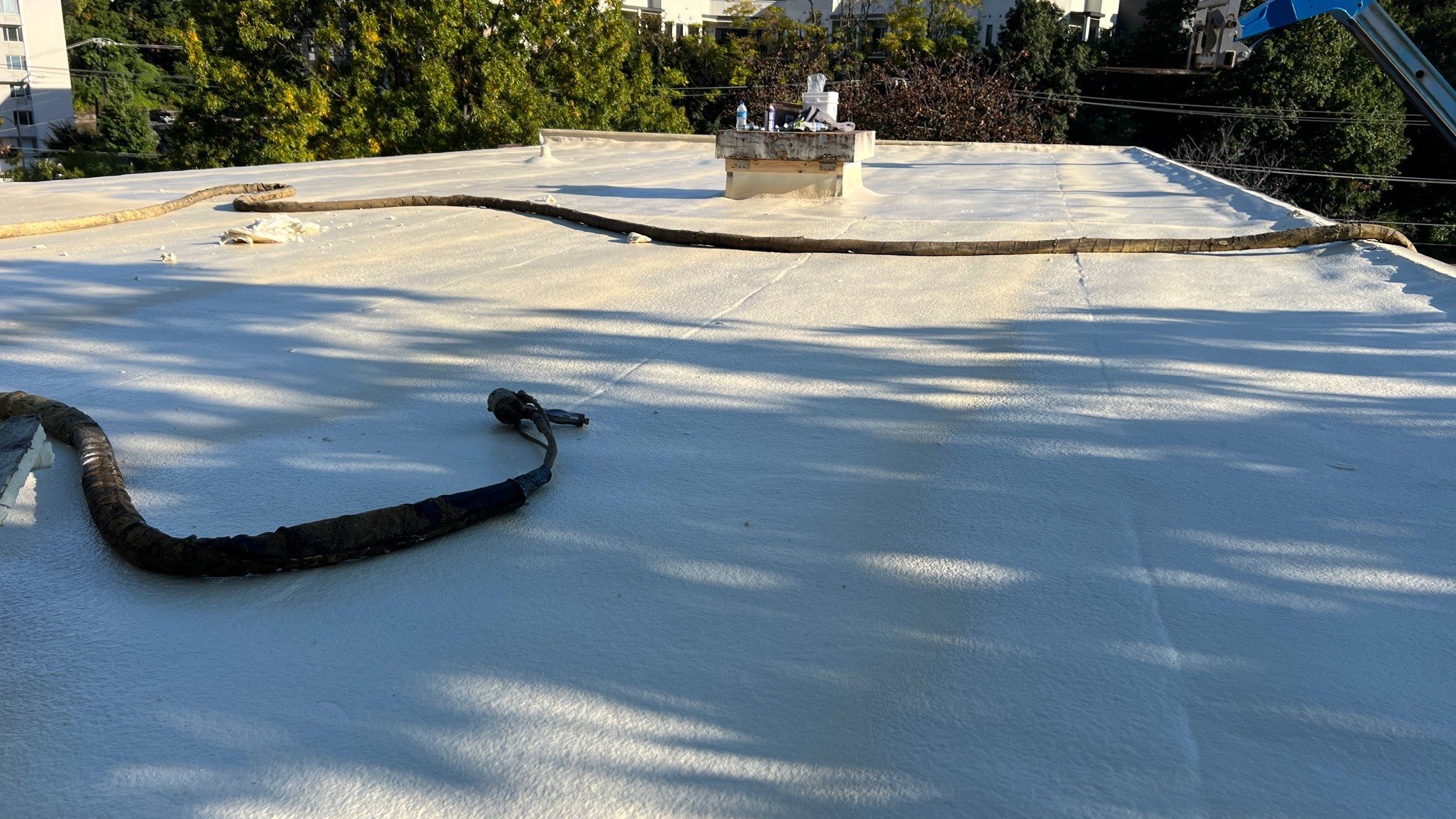 Technician performing spray foam on a commercial roof in Trinity, NC