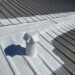 Technician performing metal roof repair on a commercial roof in Statesville, NC