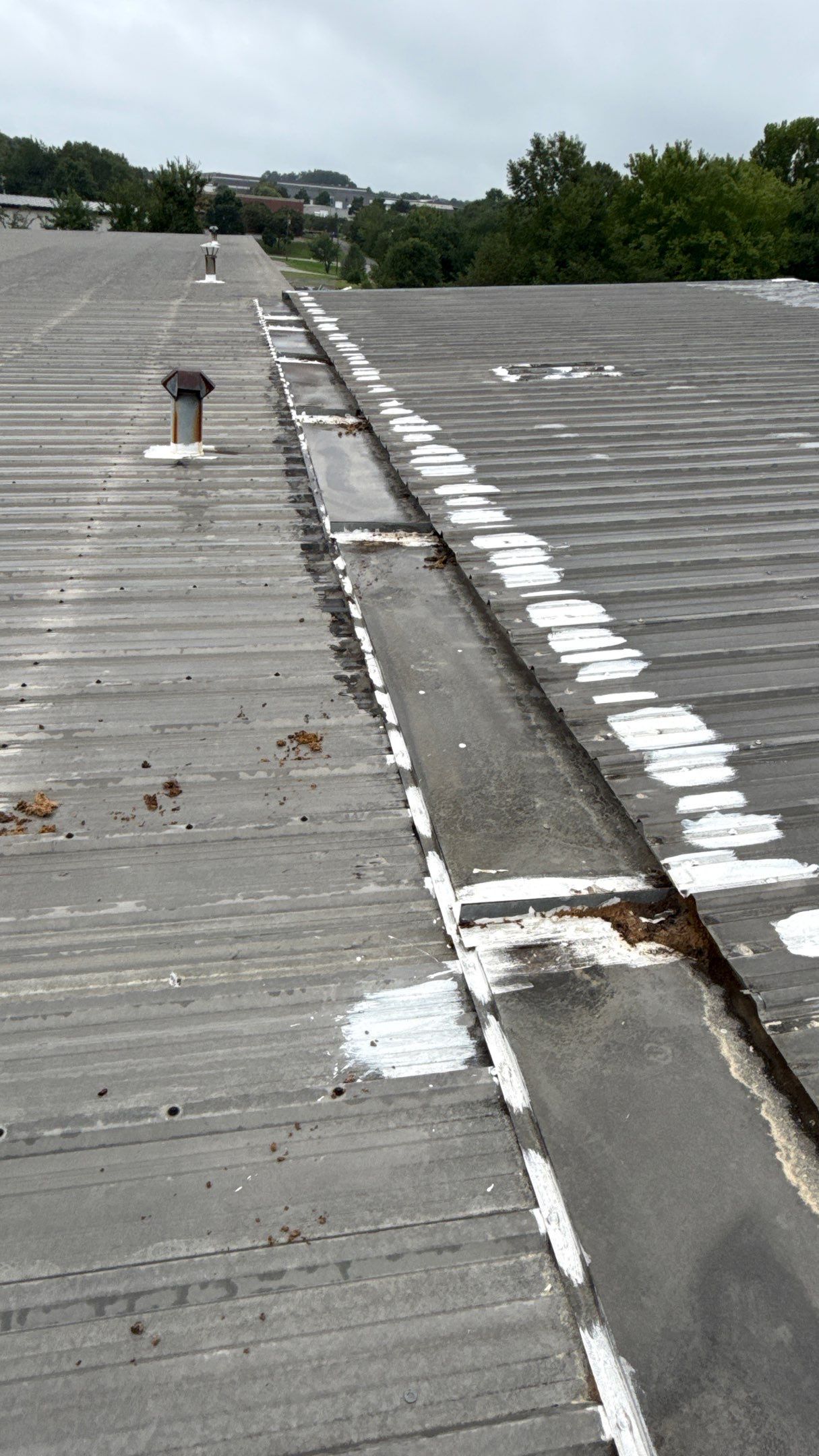 Technician performing metal roof repair on a commercial roof in Statesville, NC