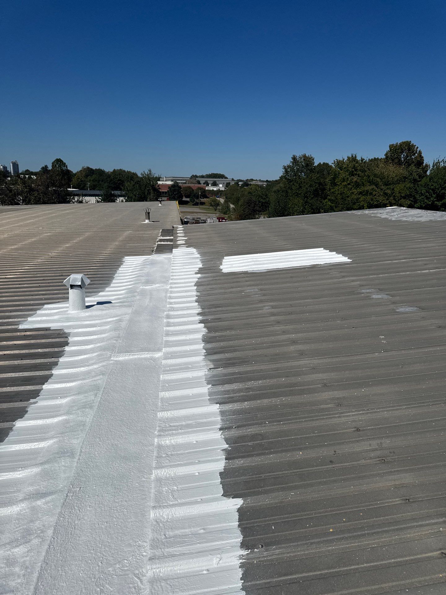Technician performing metal roof repair on a commercial roof in Statesville, NC