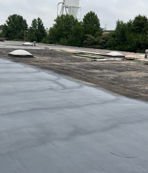workers applying a liquid-applied roof coating