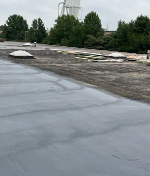 workers applying a liquid-applied roof coating
