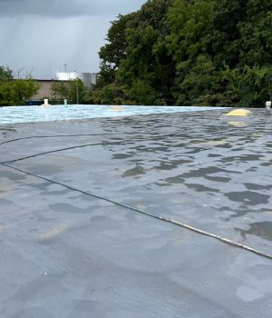 flat commercial roof undergoing a coating process